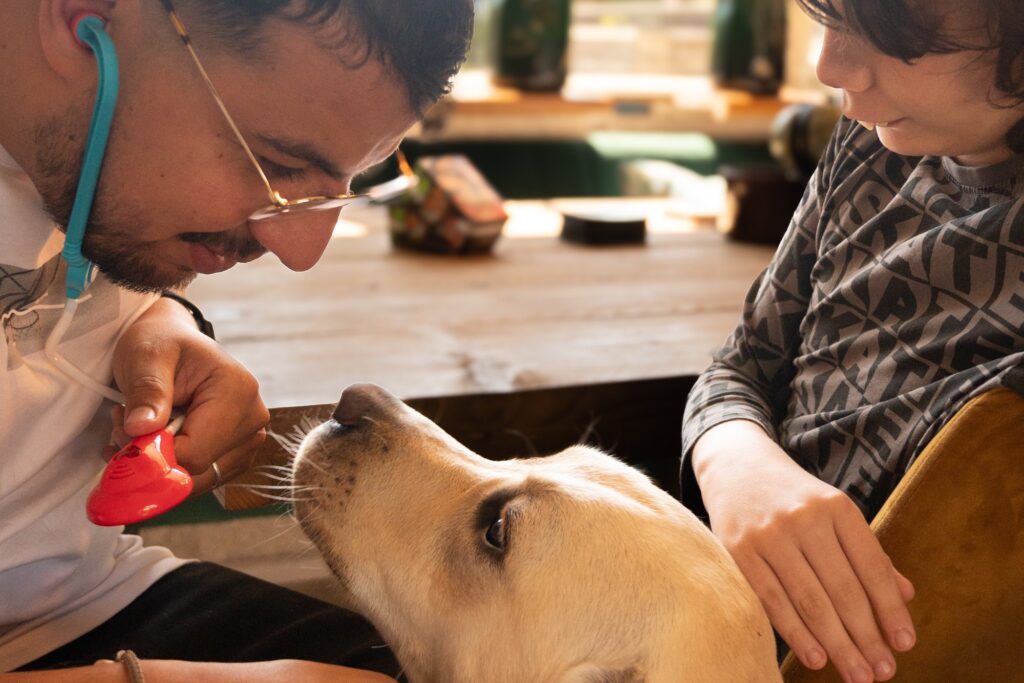 Begeleider en jongere aaien samen de hond