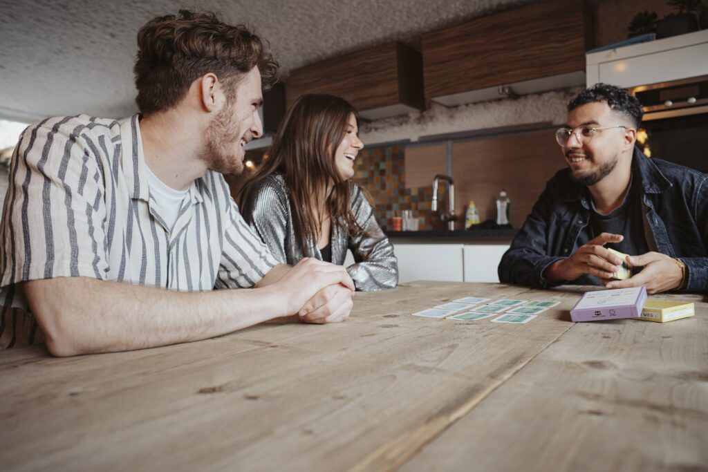 Lachen aan tafel tijdens een gesprekskaartenspel